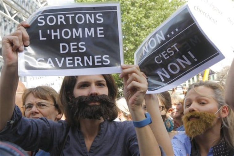 Women hold signs and wear false beards as they ptotest against sexism, rape and sexual crimes in Paris on May 22. French women's groups outraged by the political and media reaction to the sexual assault allegations against Dominique Strauss-Kahn organized the protest. 